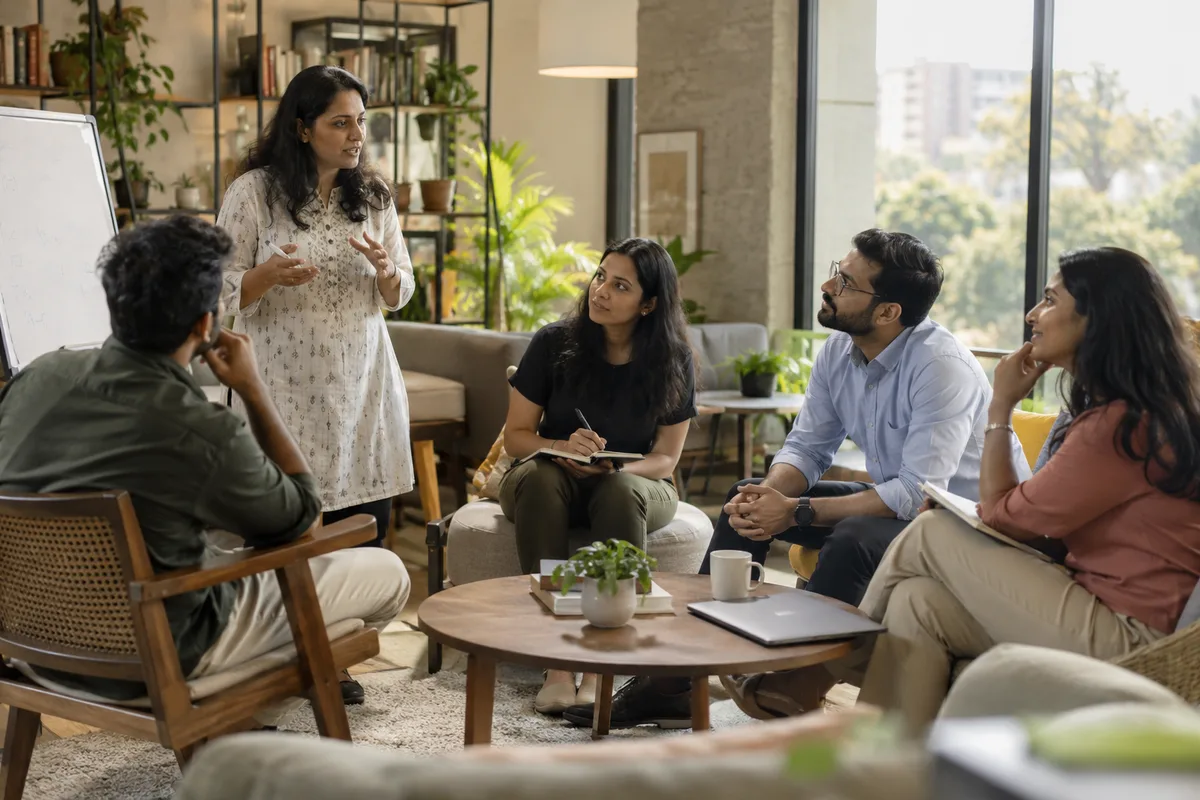 A people-management trainer guiding a small group of new managers through a discussion.